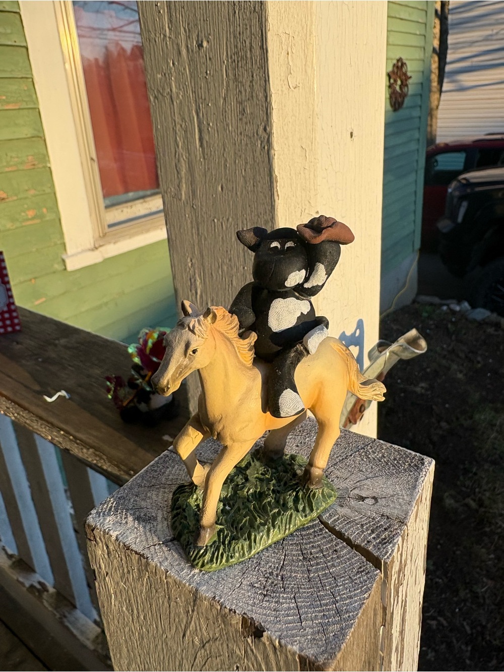 Black and White Cow Riding Yellow Horse Figurine